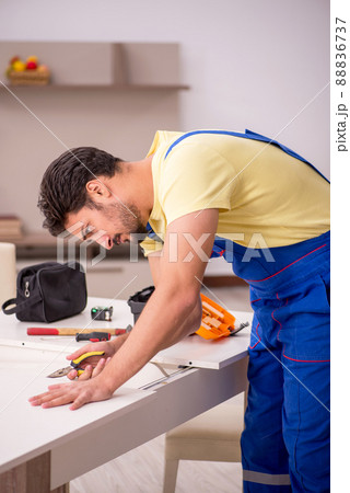 Young male carpenter repairing table at home 88836737