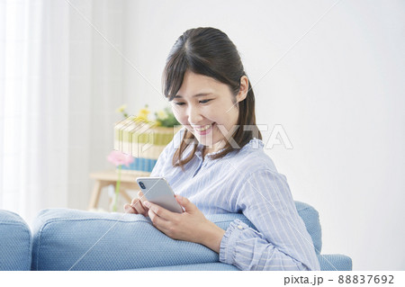 女性 スマホ 笑顔 リビング 女性 スマホ 笑顔 リビング 88837692