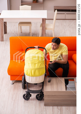 Young man looking after new born at home Young man looking after new born at home 88838156