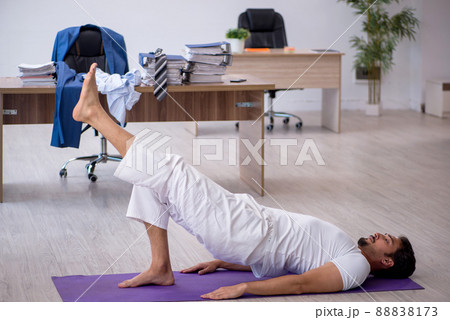 Young male employee doing sport exercises in the office 88838173