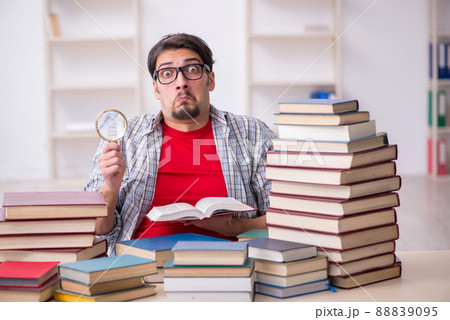 Young male student and too many books in the classroom 88839095