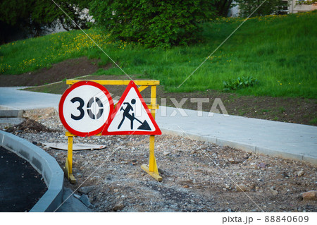 Construction road signs with number and digging man with shovel symbol on sandy road under construction Construction road signs with number and digging man with shovel symbol on sandy road under construction 88840609