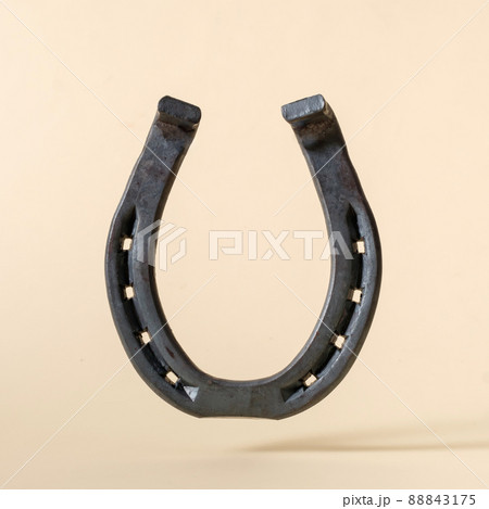 Horseshoe iron on beige background concept of american wild west. Horseshoe iron on beige background concept of american wild west. 88843175
