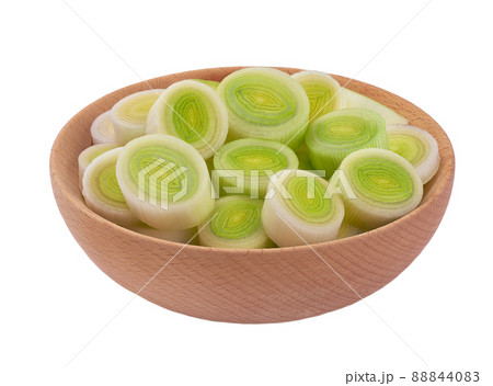 Sliced leek in a wooden bowl isolated on wooden background, with clipping path. Sliced leek in a wooden bowl isolated on wooden background, with clipping path. 88844083