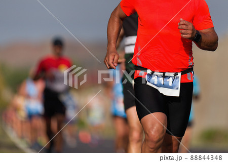 Marathon man running on the asphalt road Marathon man running on the asphalt road 88844348