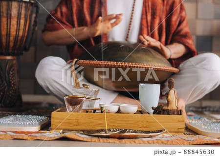 Close-up of a man's hand playing a modern musical instrument - the Orion tongue drum during the tea ceremony Close-up of a man's hand playing a modern musical instrument - the Orion tongue drum during the tea ceremony 88845630