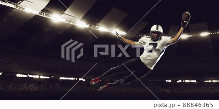 Dynamic portrait of male american football player in sports equipment at stadium in motion on dark background with flashlights. Collage, poster. Flyer for ad, design Dynamic portrait of male american football player in sports equipment at stadium in motion on dark background with flashlights. Collage, poster. Flyer for ad, design 88846365