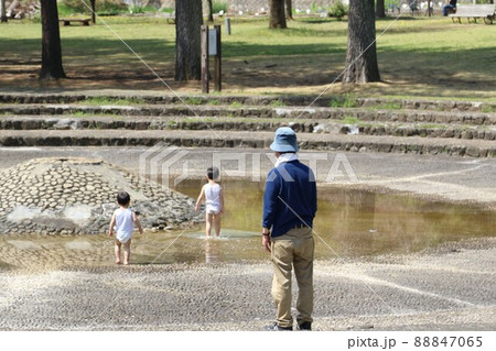 2021日本で一番幸せな町に選ばれた埼玉県鳩山町農村公園で水遊びをする幼い孫の兄弟を見守るお爺ちゃん 88847065