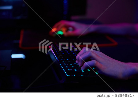 Professional gamer play computer video game in dark room, use neon colored rgb mechanical keyboard, place for cybersport gaming 88848817