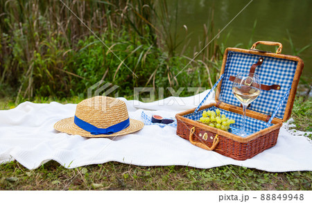 Romantic picnic in the park on the grass against the backdrop of a beautiful lake, delicious food 88849948