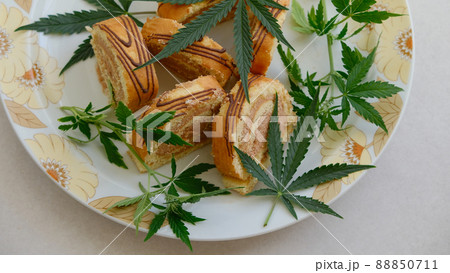 Sweet roll with marijuana oil on white plate. Cannabis kitchen Sweet roll with marijuana oil on white plate. Cannabis kitchen 88850711