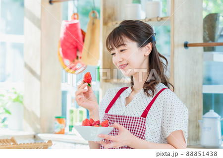 キッチンでイチゴをつまみ食いする女性 88851438