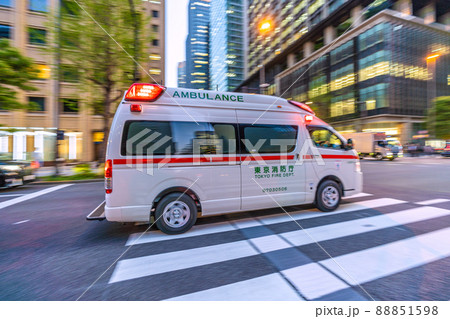 日本の東京都市景観　大手町駅前を赤信号だが安全確認をしながら緊急走行する救急車 88851598