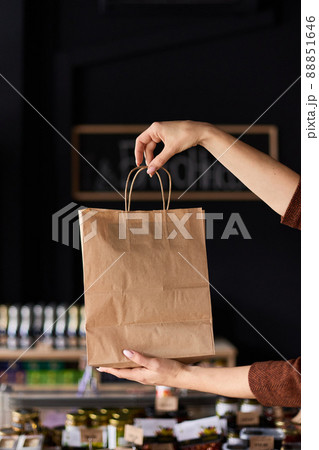 The girl holds a paper bag in her hands 88851646