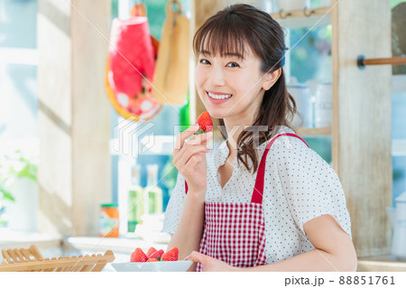 キッチンでイチゴをつまみ食いする女性 88851761