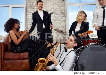 Young international musicians, a band performing on the loft stage. The concept of music, hobby, festival. Inspiration creativity. 88851765
