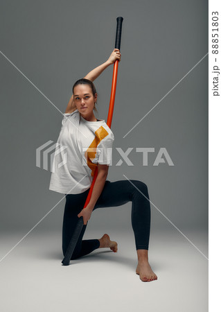beautiful girl in sports uniform is training kung fu in the studio, fighter athlete, practicing martial arts with a stick 88851803