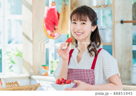 キッチンでイチゴをつまみ食いする女性 88851945
