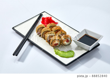 Hot Sushi roll isolated on white background. Traditional fresh Japanese Sushi roll with salmon, avocado, and philadelphia cheese Hot Sushi roll isolated on white background. Traditional fresh Japanese Sushi roll with salmon, avocado, and philadelphia cheese 88852840