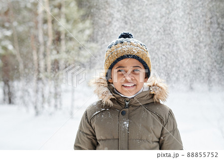 Cheerful little boy of African ethnicity wearing warm winter jacket and beanie 88855752