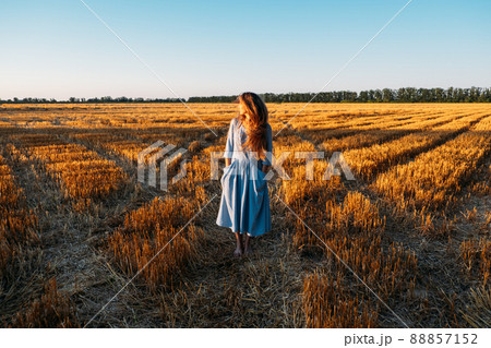 Stress and psychological resilience. Spend Time in Nature to Reduce Stress and Anxiety. Nature break relieves stress. Young woman in blue dress enjoying nature and walking in sunset field Stress and psychological resilience. Spend Time in Nature to Reduce Stress and Anxiety. Nature break relieves stress. Young woman in blue dress enjoying nature and walking in sunset field 88857152