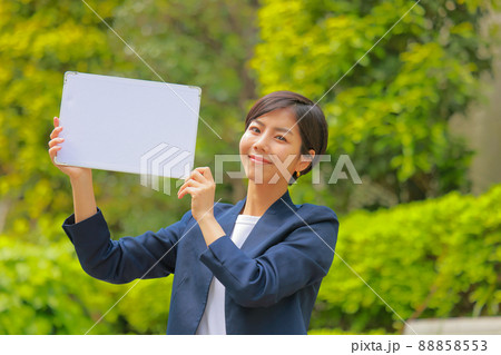 メッセージボードを掲げるネイビーのジャケットの女性1 88858553