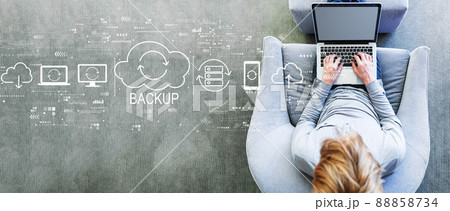 Backup concept with man using a laptop Backup concept with man using a laptop 88858734