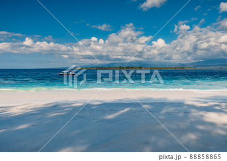 Sandy beach and blue ocean in paradise island. Holiday beach with white sand and sea water Sandy beach and blue ocean in paradise island. Holiday beach with white sand and sea water 88858865