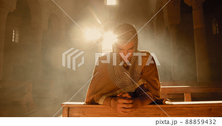 Young Viking man prays in a large church Young Viking man prays in a large church 88859432