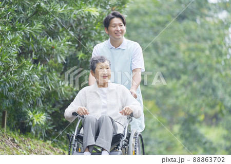 介護士と車椅子に乗った高齢者 屋外 介護士と車椅子に乗った高齢者 屋外 88863702