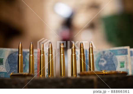 A view from a distance of live ammunition and files of paper cash. 88866361