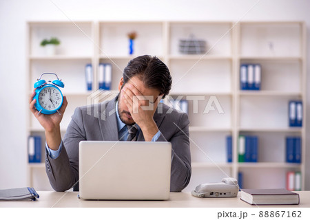 Young male employee in time management concept Young male employee in time management concept 88867162