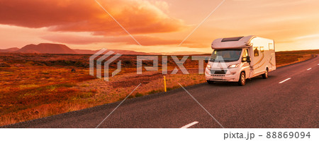 Motorhome camper van RV road trip. People on travel vacation adventure. Tourists in rental car campervan by view of mountains in beautiful nature landscape at sunset Motorhome camper van RV road trip. People on travel vacation adventure. Tourists in rental car campervan by view of mountains in beautiful nature landscape at sunset 88869094