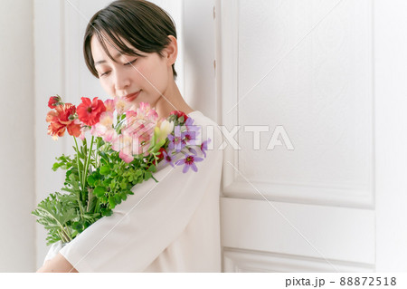 花を抱える女性 笑顔の写真素材