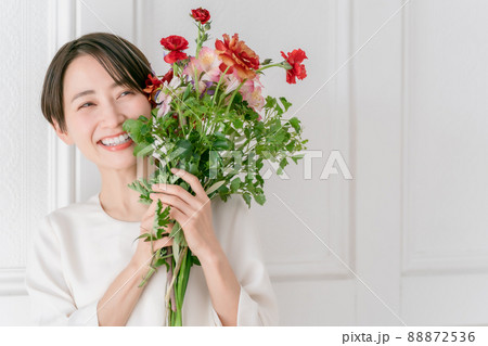 花を抱える女性 笑顔の写真素材