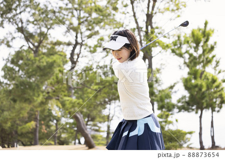 フェアウェイでスイングをする若い女性 88873654