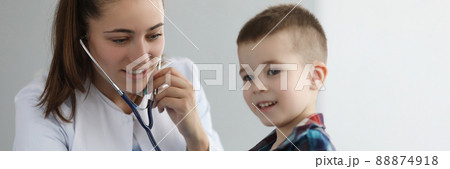 Doctor pediatrician listening to heart with stethoscope to little boy in clinic 88874918