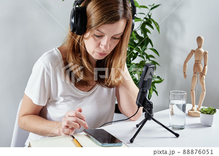 Woman listening online course in headphones, distance education. Freelancer sitting at workplace and procrastinating. Lazy and distracted employee Woman listening online course in headphones, distance education. Freelancer sitting at workplace and procrastinating. Lazy and distracted employee 88876051