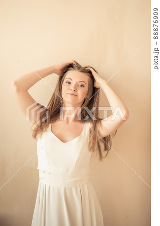 young girl with fingers in her hair, looking at camera and smiling young girl with fingers in her hair, looking at camera and smiling 88876909