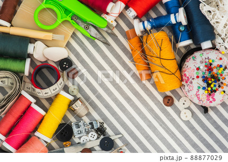 Sewing tools on striped background top view Sewing tools on striped background top view 88877029