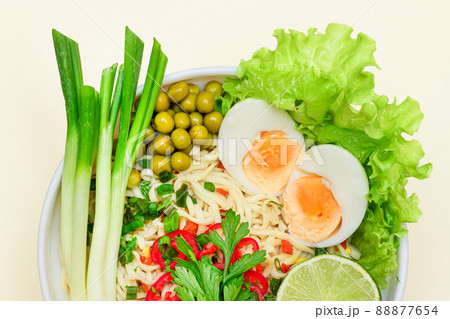 Noodle Dish with Green Onions, Eggs, Green Pea, Red Hot Pepper, Greens and Lime 88877654