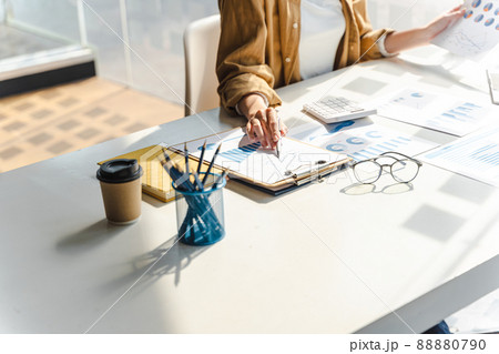 Close-up of business woman hands check company finance data reports at desk in modern office. 88880790