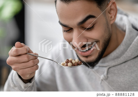 A young man having breakfast and smiling 88881128