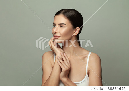 Beautiful smiling woman with natural makeup and clean skin on grey background Beautiful smiling woman with natural makeup and clean skin on grey background 88881692