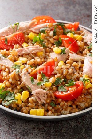 Boiled spelled with tuna, corn, tomatoes and herbs close-up in a plate. vertical Boiled spelled with tuna, corn, tomatoes and herbs close-up in a plate. vertical 88885107
