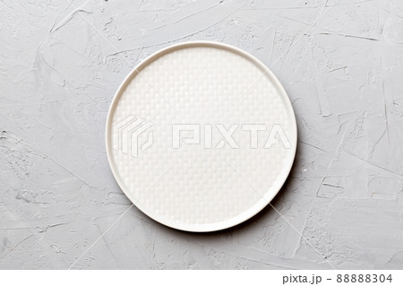 Top view of empty light plate on cement background. Empty space for your design 88888304