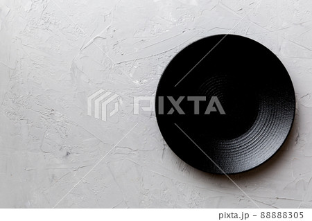 Top view of black plate on cement background. Empty space for your design 88888305