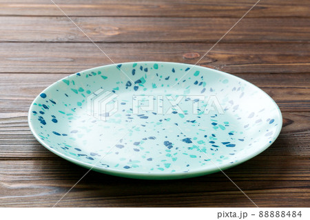 Perspective view of empty blue plate on wooden background. Empty space for your design 88888484