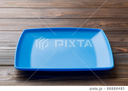 Perspective view of empty square plate on wooden background. Empty space for your design 88888485