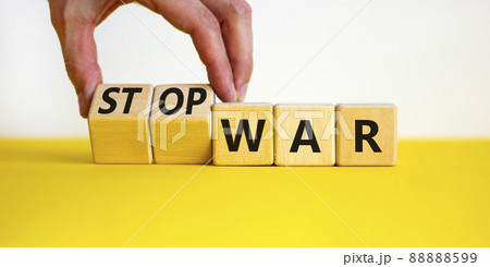 Stop war symbol. Businessman turns cubes and changes concept words War to Stop war. Beautiful yellow table white background. Business and stop war concept. Copy space. Stop war symbol. Businessman turns cubes and changes concept words War to Stop war. Beautiful yellow table white background. Business and stop war concept. Copy space. 88888599